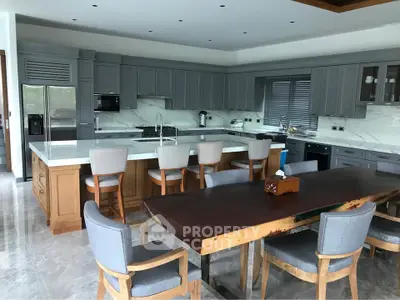 Luxurious modern kitchen with open layout and high-end appliances, featuring a spacious dining area and elegant cabinetry.
