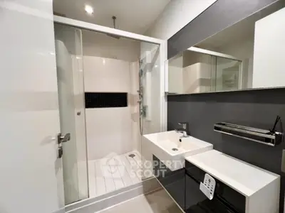 Modern bathroom with sleek shower and stylish sink in contemporary design.