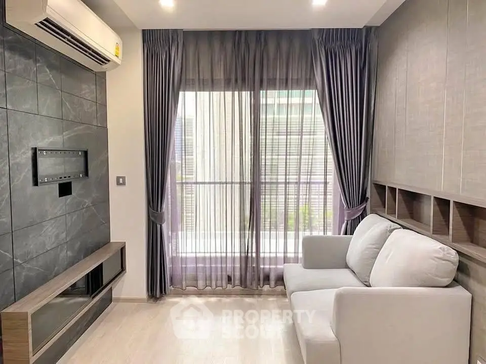 Modern living room with sleek design, featuring a cozy sofa and large window with elegant curtains.