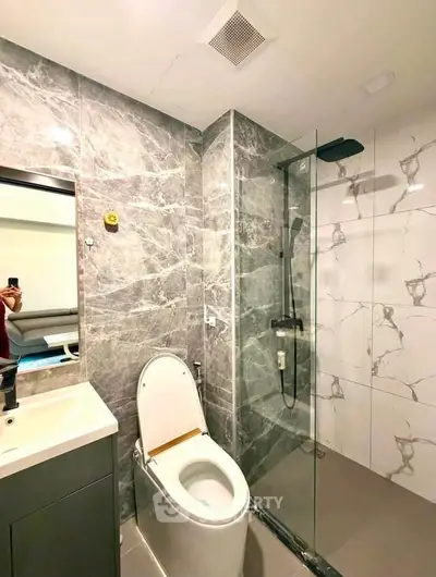 Modern bathroom with marble tiles and glass shower enclosure