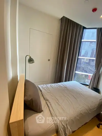 Cozy modern bedroom with large window and stylish decor in urban apartment