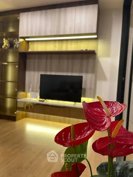 Modern living room with sleek TV unit and vibrant red flowers