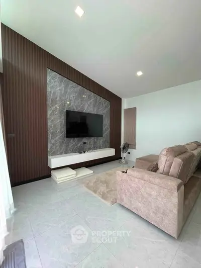 Modern living room with sleek TV wall, plush sofa, and elegant decor