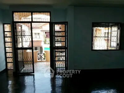 Spacious living room with large windows and balcony access in a modern home.