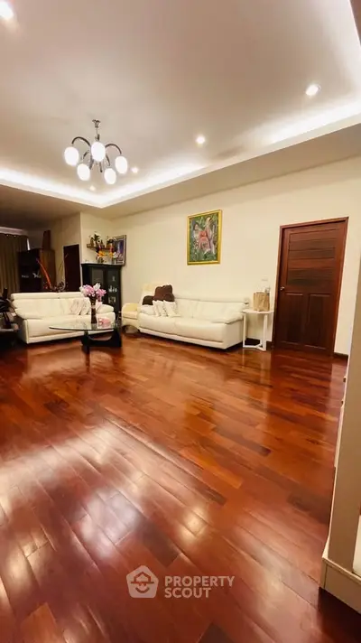 Spacious living room with elegant wooden flooring and modern lighting