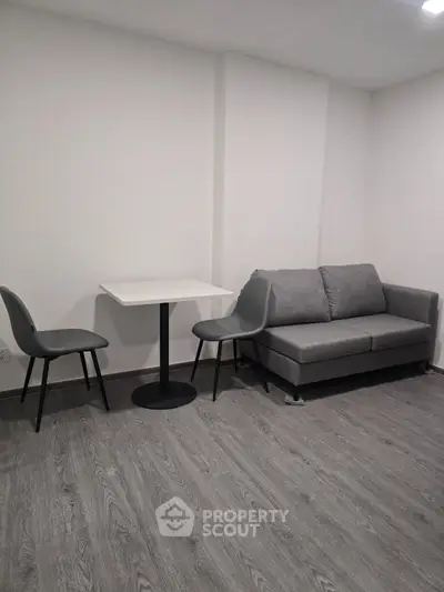 Modern minimalist living room with gray sofa and dining set