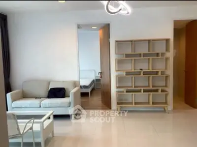 Modern living room with minimalist furniture and open view to bedroom