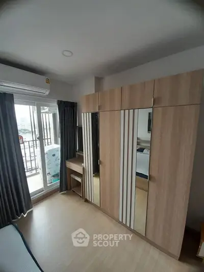 Modern bedroom with large wardrobe and balcony access in a stylish apartment.
