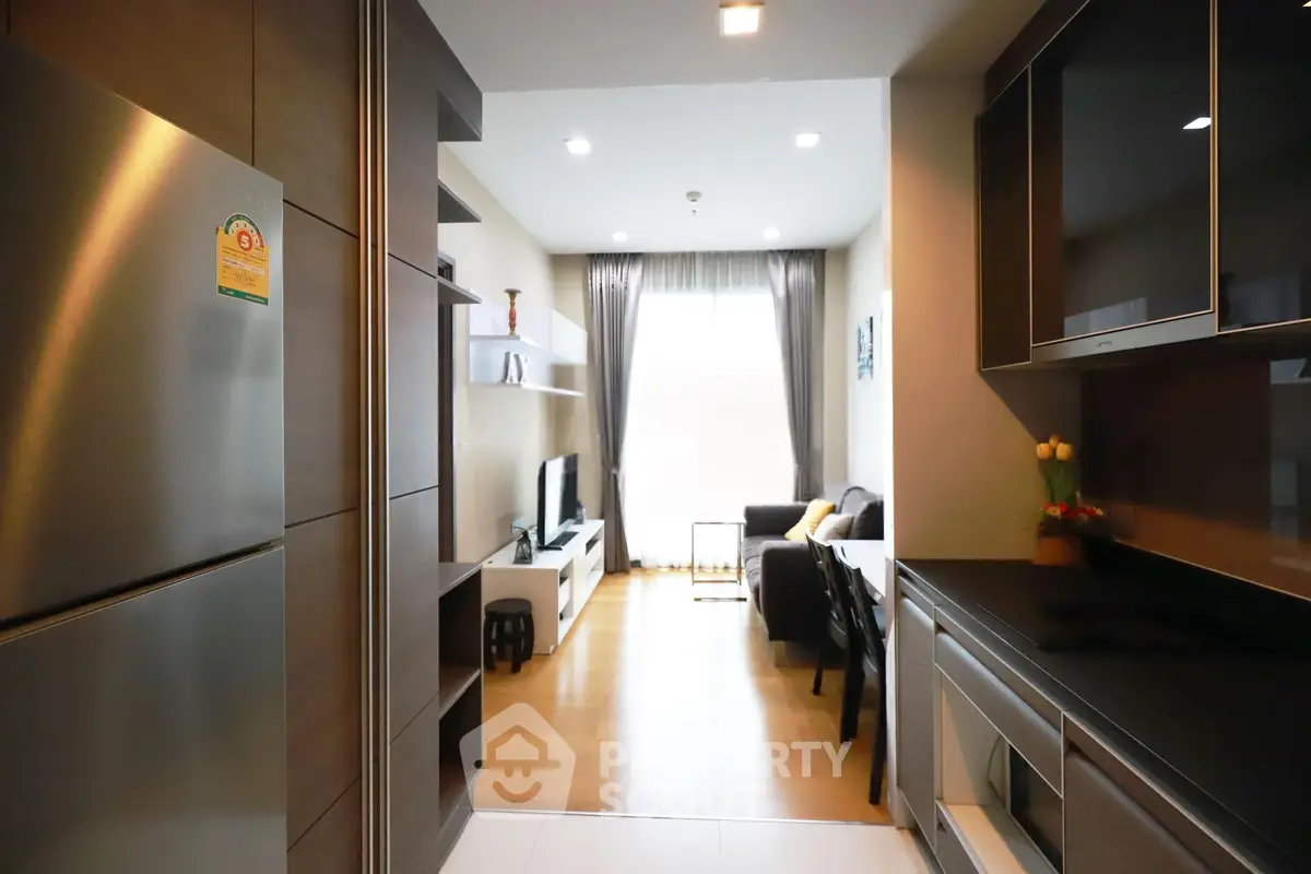 Modern open-layout kitchen and living room with sleek appliances and cozy seating area.