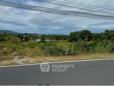 Scenic land plot with mountain views and lush greenery, ideal for development.