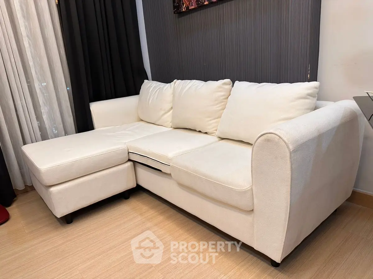 Elegant white sectional sofa in modern living room with stylish decor.