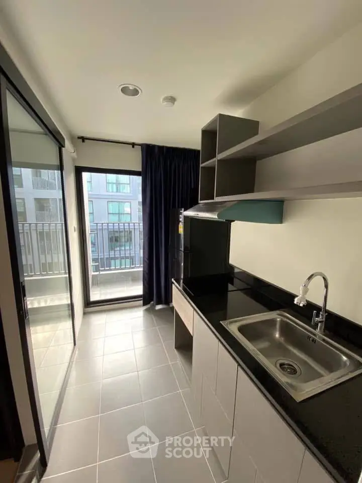 Modern kitchen with sleek design and balcony view in urban apartment