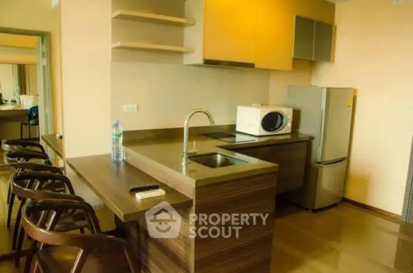 Modern kitchen with sleek countertops and appliances in a stylish apartment.