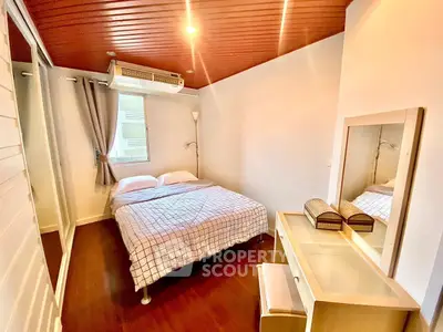 Cozy bedroom with wooden ceiling and modern furnishings