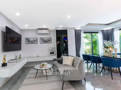 Elegant living room with modern decor, large windows, and stylish furniture.