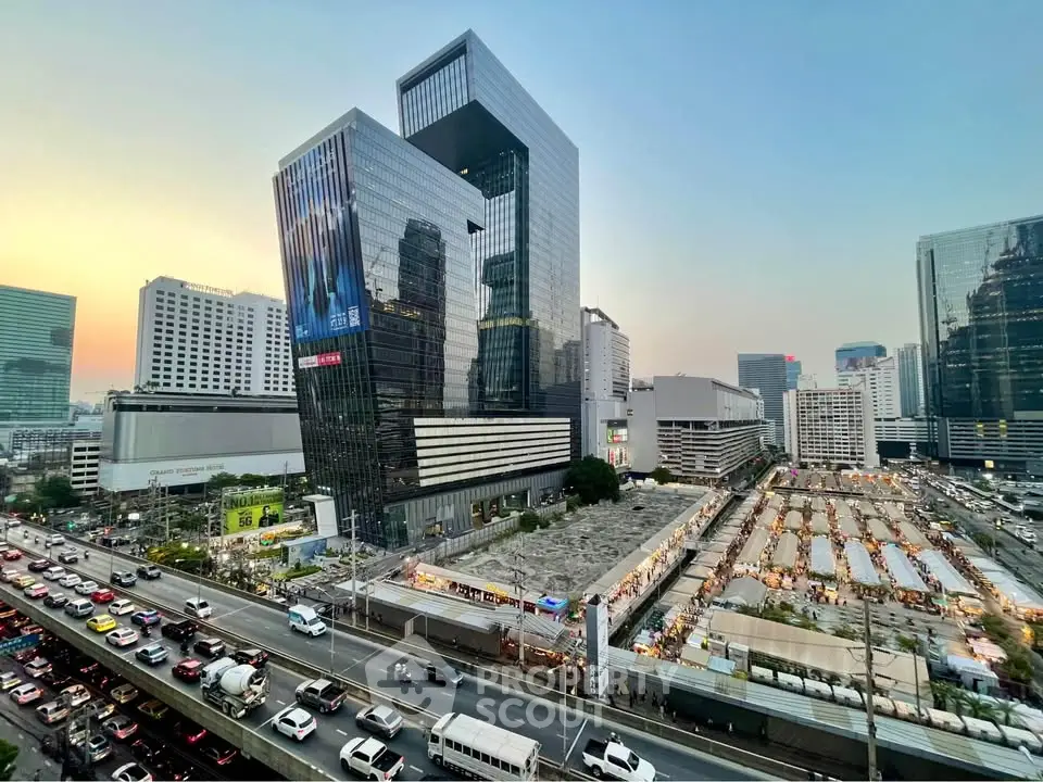 Stunning cityscape view with modern high-rise buildings and bustling street traffic at sunset.