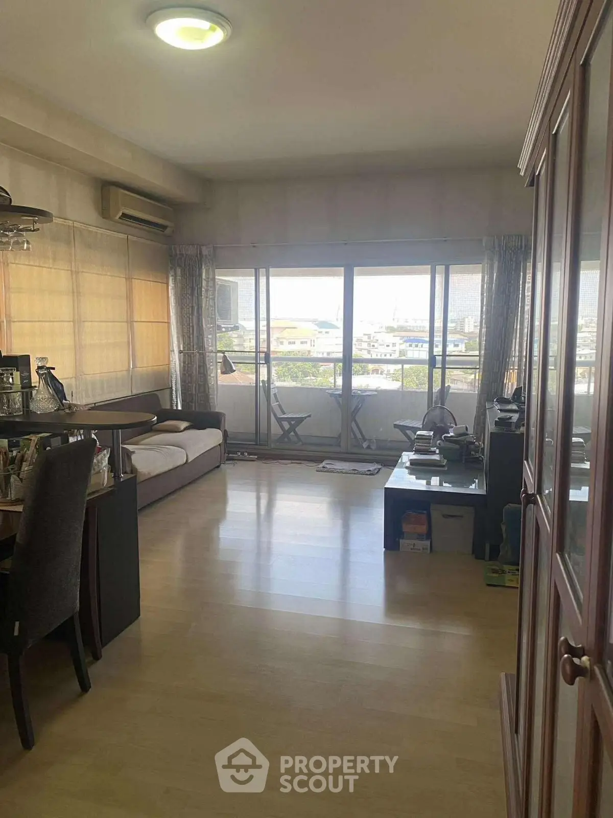 Spacious living room with large windows and balcony offering a great view, perfect for relaxation.