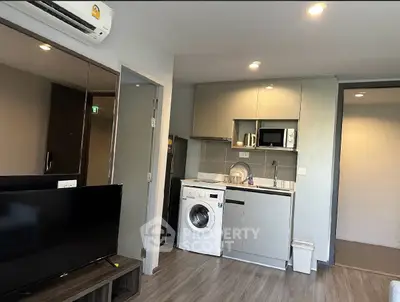 Modern compact kitchen with washing machine and microwave in stylish apartment