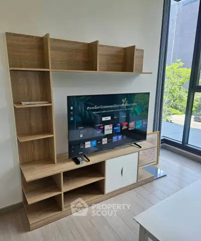 Modern living room with stylish wooden TV stand and large window view
