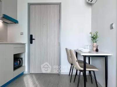 Modern compact dining area with sleek table and chairs, adjacent to a stylish kitchen corner in a cozy apartment.