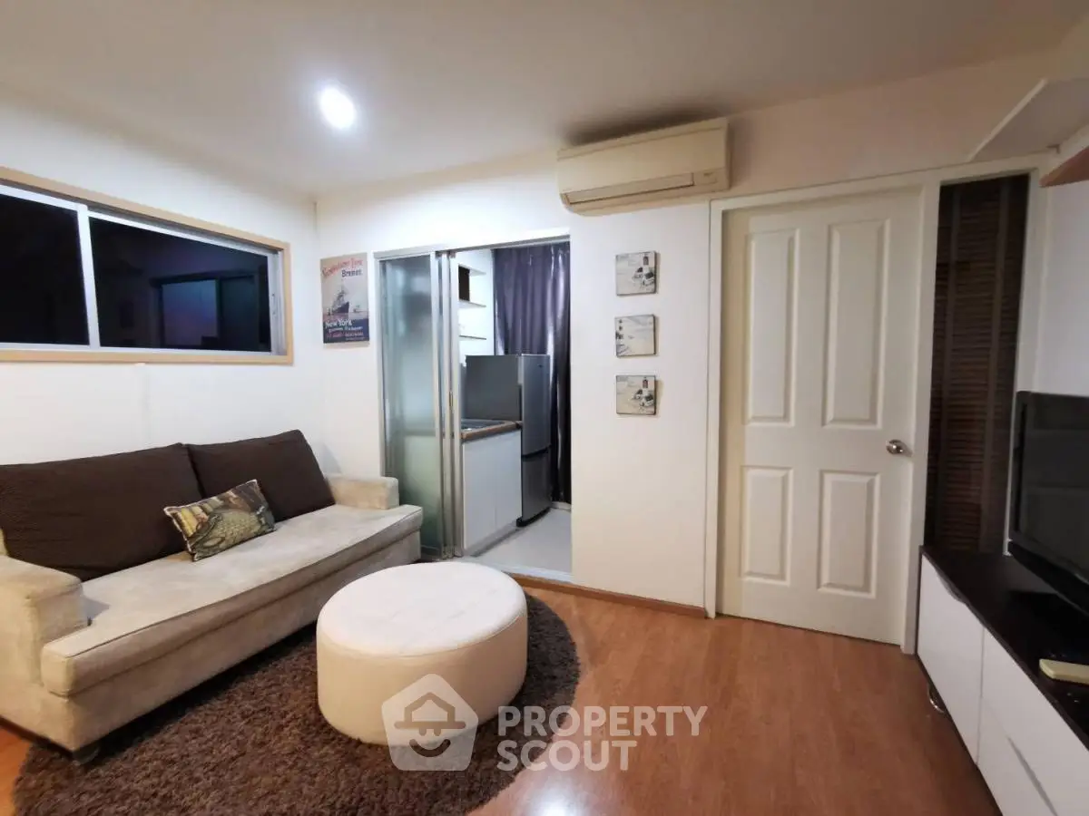 Cozy living room with modern decor and adjacent kitchen area.
