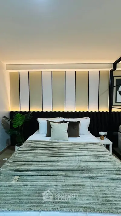 Luxurious modern bedroom with elegant lighting and plush bedding, perfect for relaxation and comfort.