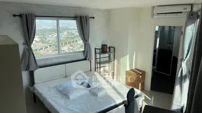 Modern bedroom with city view, featuring a comfortable bed, air conditioning, and stylish decor.