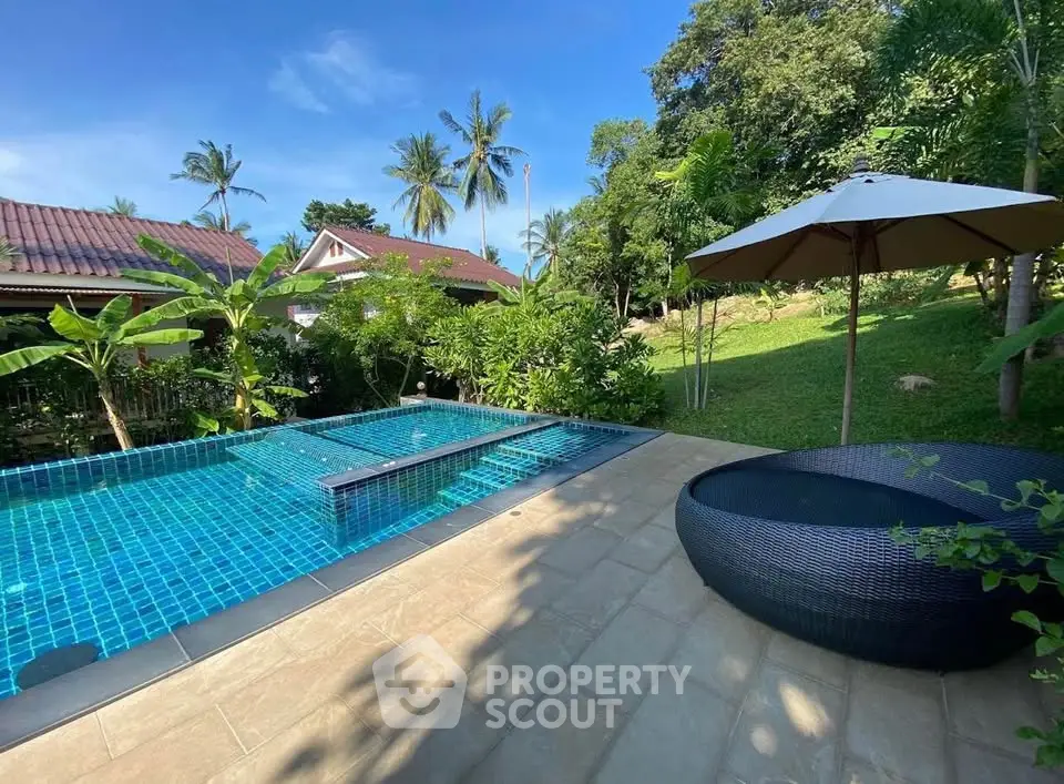 Luxurious outdoor pool area with lush greenery and modern seating, perfect for relaxation and entertainment.