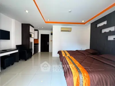 Modern bedroom with stylish decor and kitchenette in a contemporary apartment.