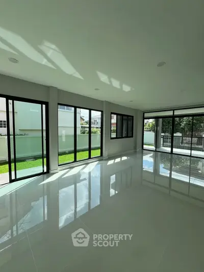 Spacious modern living room with large windows and garden view, perfect for natural light lovers.