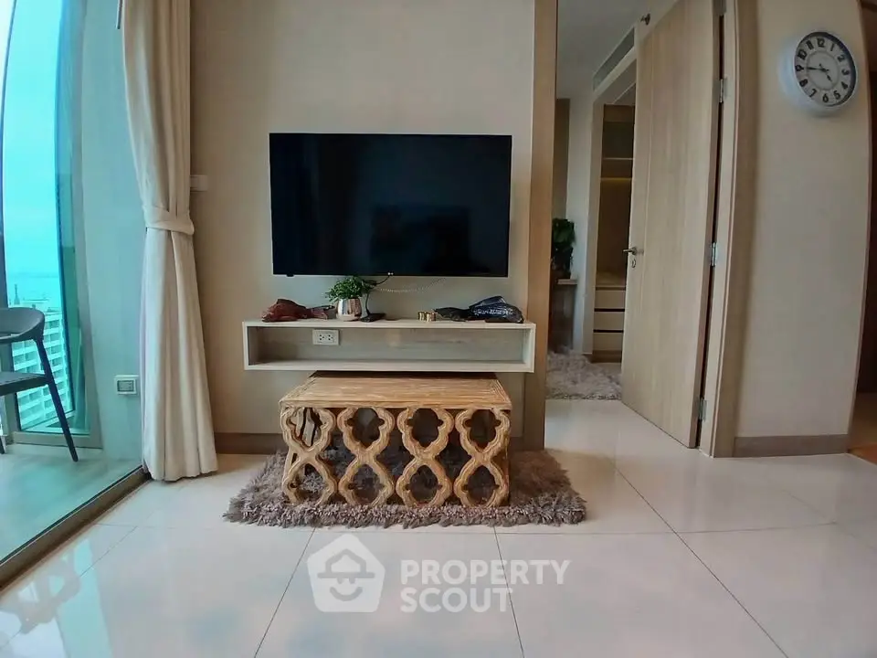 Modern living room with stylish TV setup and balcony view
