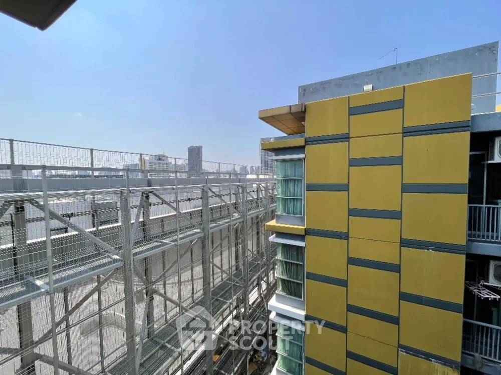 Modern urban building with city view and metal scaffolding, showcasing contemporary architecture.