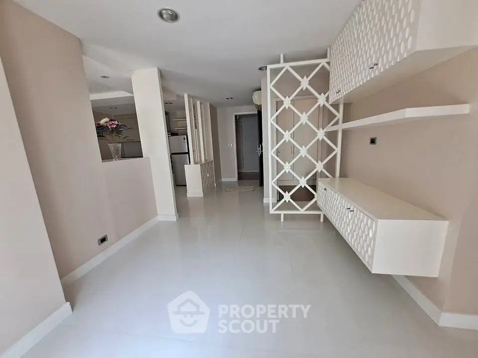 Spacious modern living room with elegant partition and sleek shelving in a stylish apartment.