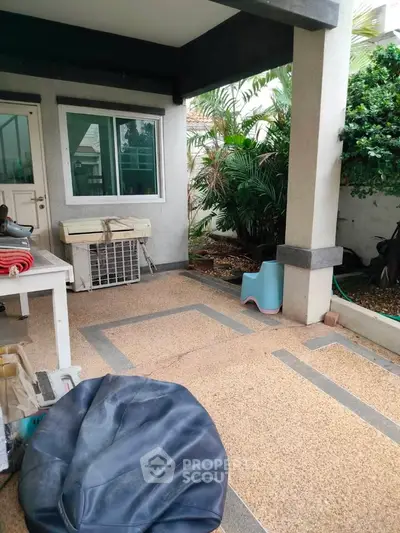 Charming garden patio with lush greenery and cozy seating area for relaxation.