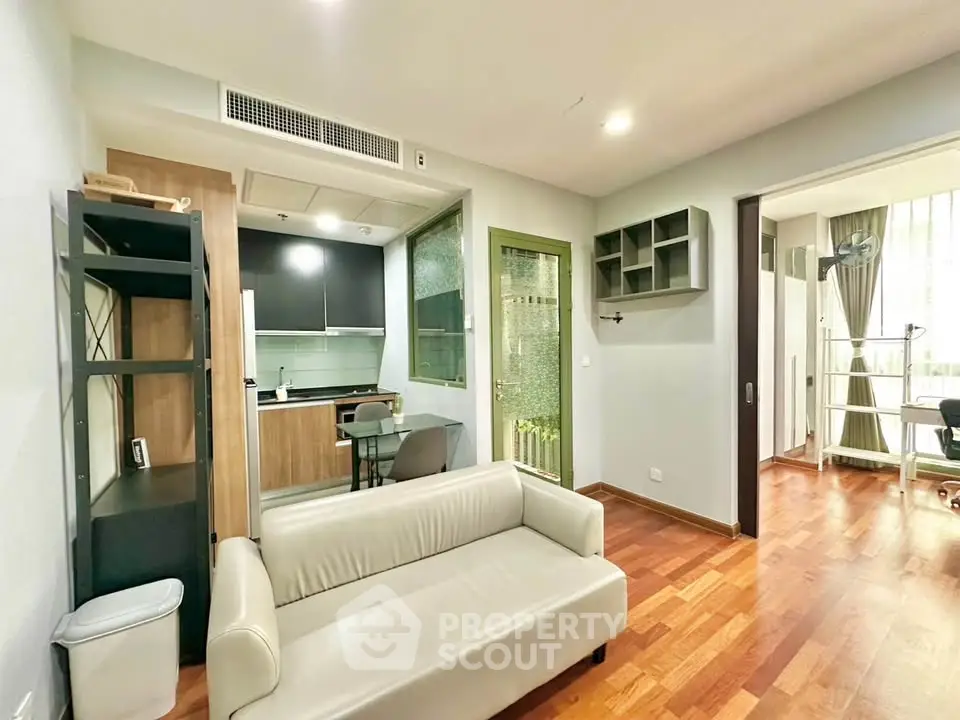 Modern living room with open kitchen and wooden flooring in a cozy apartment