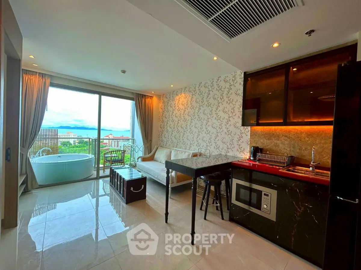 Luxurious open-plan living room with stunning ocean view and modern kitchenette.