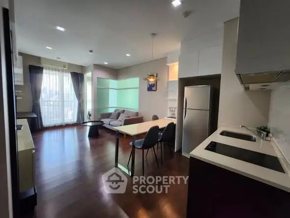 Modern open-layout living room and kitchen with sleek design and natural light.