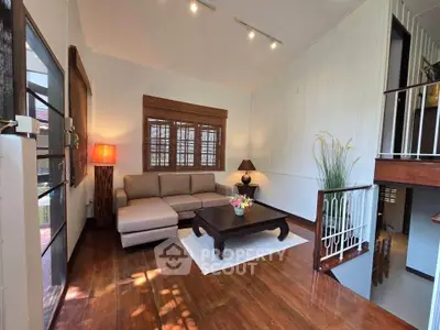 Charming living room with cozy sectional sofa and elegant wooden flooring, perfect for relaxation and entertaining.