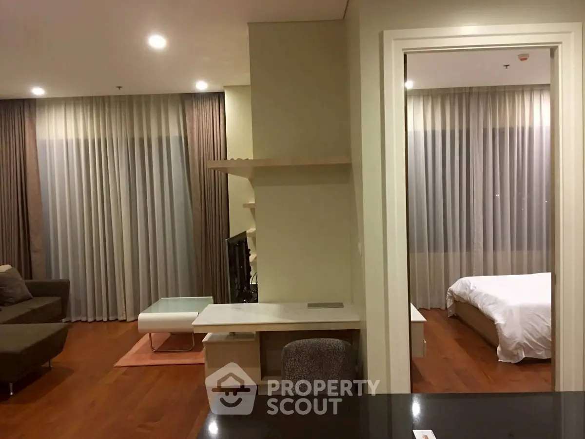 Modern apartment interior with cozy living room and elegant bedroom, featuring stylish furniture and warm lighting.