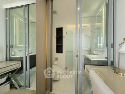 Modern bathroom with glass shower and sleek fixtures in luxury apartment