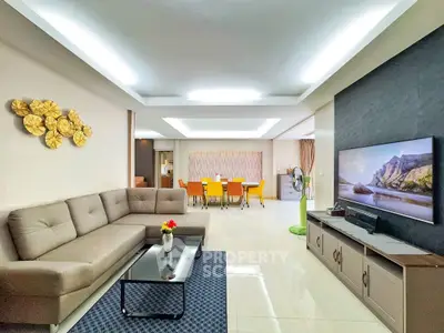 Spacious modern living room with elegant decor and open dining area, perfect for family gatherings.