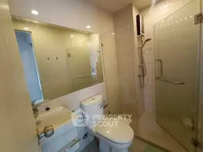 Modern bathroom with glass shower and sleek fixtures in a contemporary apartment.