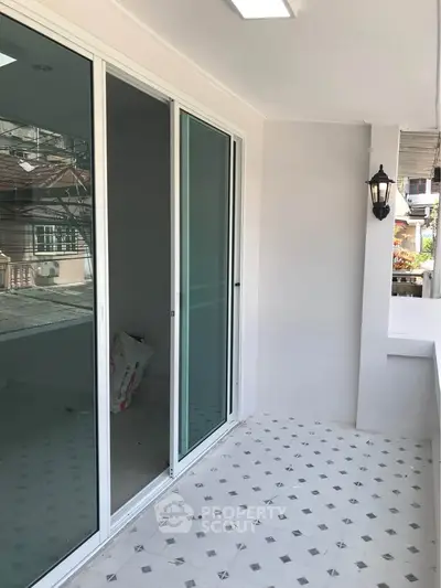 Spacious balcony with sliding glass doors and elegant outdoor lighting, perfect for relaxation.