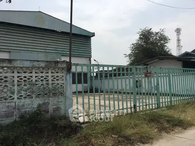 Industrial property with gated entrance and spacious outdoor area, ideal for commercial use.
