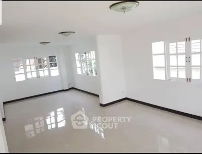 Spacious and bright empty room with large windows and tiled flooring, ideal for customization.