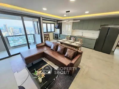 Luxurious open-plan living room with stunning city view and modern kitchen in high-rise apartment.