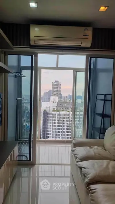 Modern living room with city view and balcony access in high-rise apartment