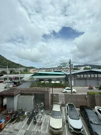 Scenic view from a parking lot with mountains and buildings in the background.