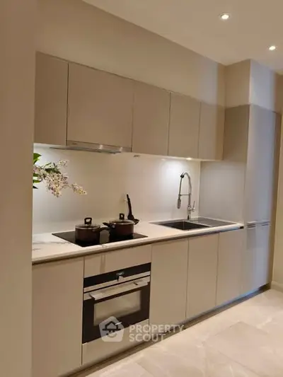 Modern kitchen with sleek cabinetry and built-in oven, ideal for contemporary living.