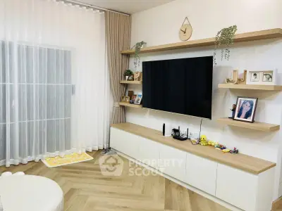 Modern living room with stylish decor, wall-mounted TV, and elegant shelving.